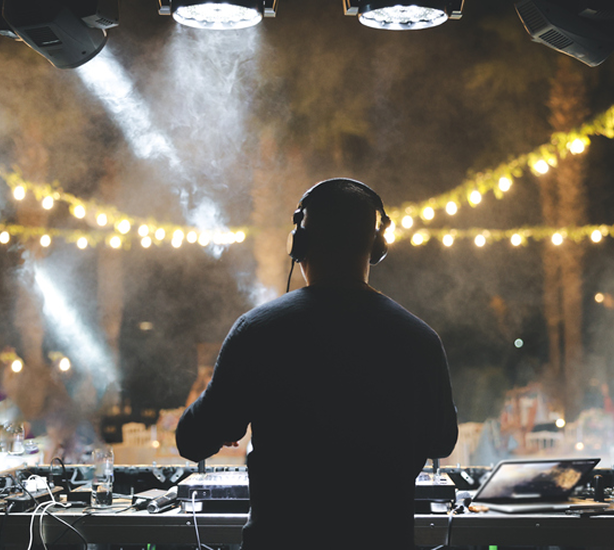 DJ mixing music under string lights
